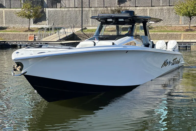 Slide: The Image of 2025 Nor-Tech 450 Sport Center Console boat docked in calm waters. - 8