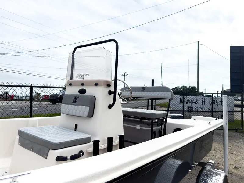 Slide: The Image of 2025 Carolina Skiff 16 JVX CC boat with console and seating, displayed outdoors. - 2