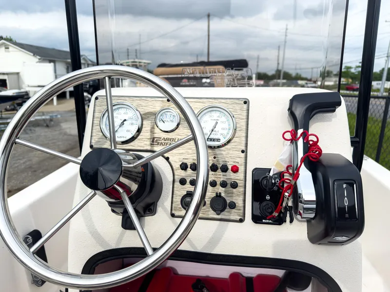 Slide: The Image of 2025 Carolina Skiff 16 JVX CC boat dashboard with steering wheel and control panel. - 5