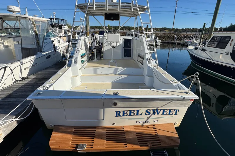 Slide: The Image of 1986 Luhrs Tournament 290 boat named "Reel Sweet" docked in a marina. - 11