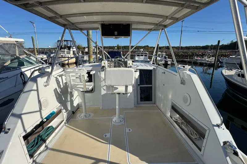 Slide: The Image of 1986 Luhrs Tournament 290 boat cockpit with helm, seating, and marina view. - 14