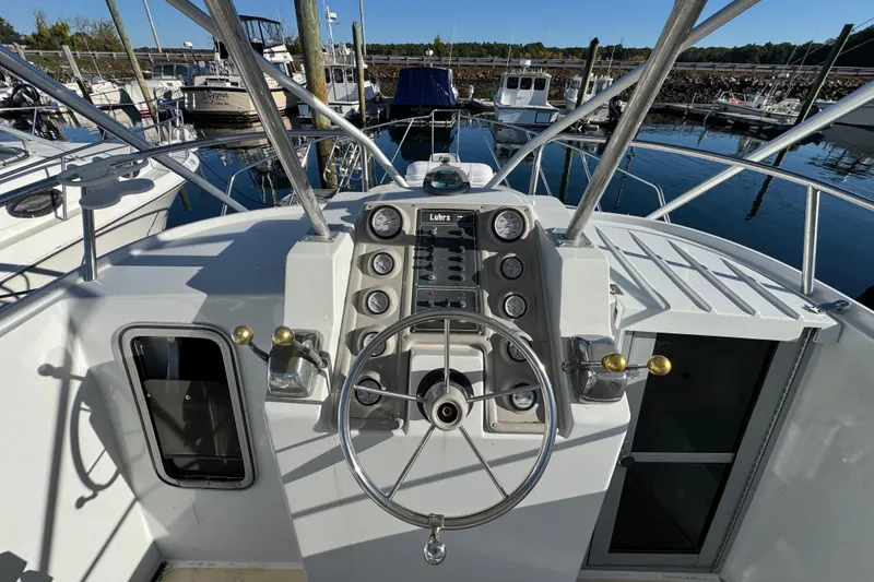 Slide: The Image of 1986 Luhrs Tournament 290 boat helm with steering wheel and control panel at marina. - 16