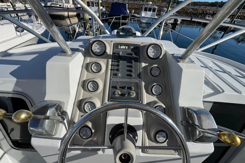 Slide: The Image of 1986 Luhrs Tournament 290 boat dashboard with gauges and steering wheel at marina. - 17