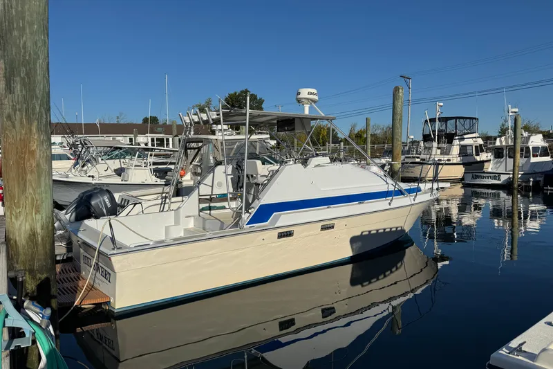 Slide: The Image of 1986 Luhrs Tournament 290 boat docked in a marina under clear blue skies. - 2