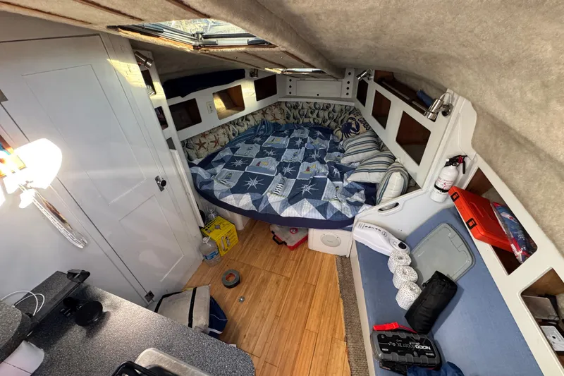 Slide: The Image of 1986 Luhrs Tournament 290 cabin interior with bed, storage, and nautical decor. - 22