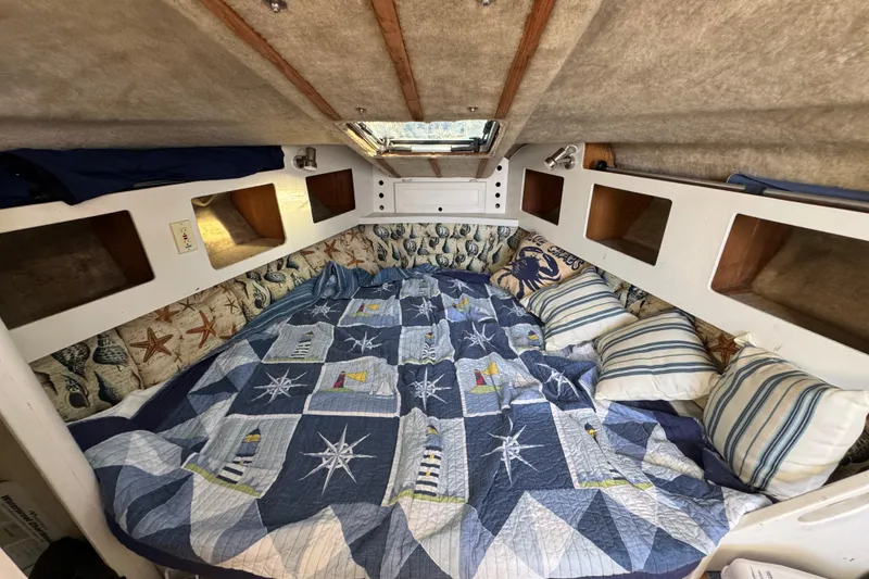 Slide: The Image of Cozy cabin interior of 1986 Luhrs Tournament 290 with nautical-themed bedding and pillows. - 23