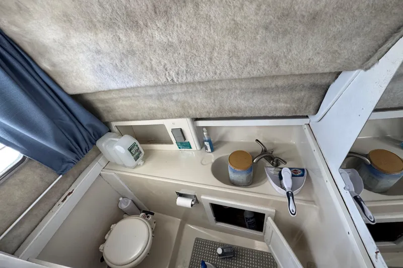 Slide: The Image of 1986 Luhrs Tournament 290 boat bathroom with sink, toilet, and toiletries. - 27