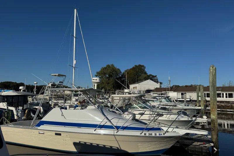 Slide: The Image of 1986 Luhrs Tournament 290 boat docked at marina under clear blue sky. - 3