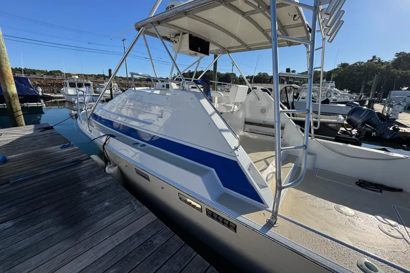 Slide: The Image of 1986 Luhrs Tournament 290 boat docked, featuring sleek design and blue accents. - 8