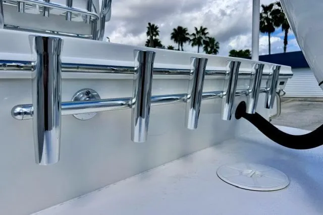 Slide: The Image of 2026 Pair Customs 24 Center Console DV boat with chrome rod holders, palm trees in background. - 15