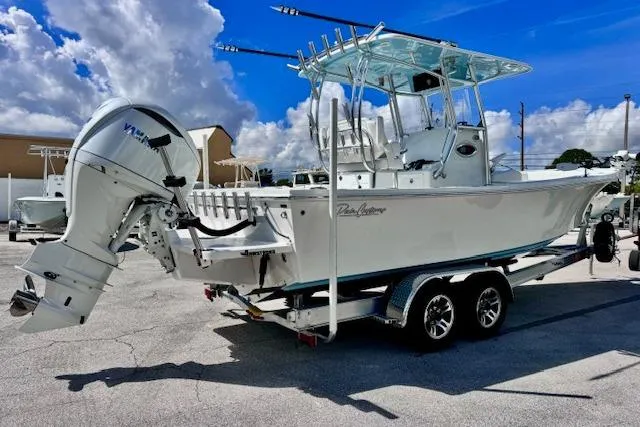 Slide: The Image of 2026 Pair Customs 24 Center Console DV boat on trailer, under clear blue sky. - 5