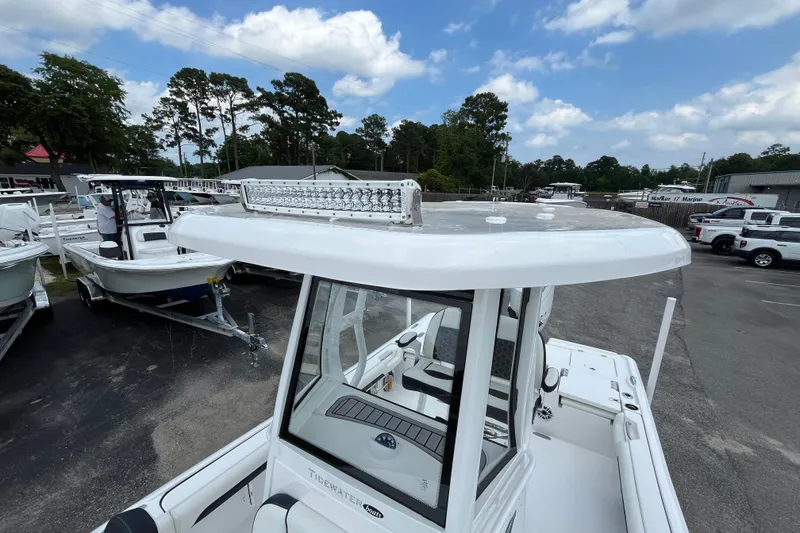 Slide: The Image of 2023 Tidewater 2500 Carolina Bay boat with T-top and LED light bar, parked outdoors. - 13