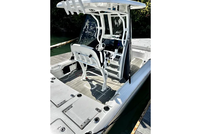 Slide: The Image of 2023 Tidewater 2500 Carolina Bay boat interior with console and seating, docked by water. - 20