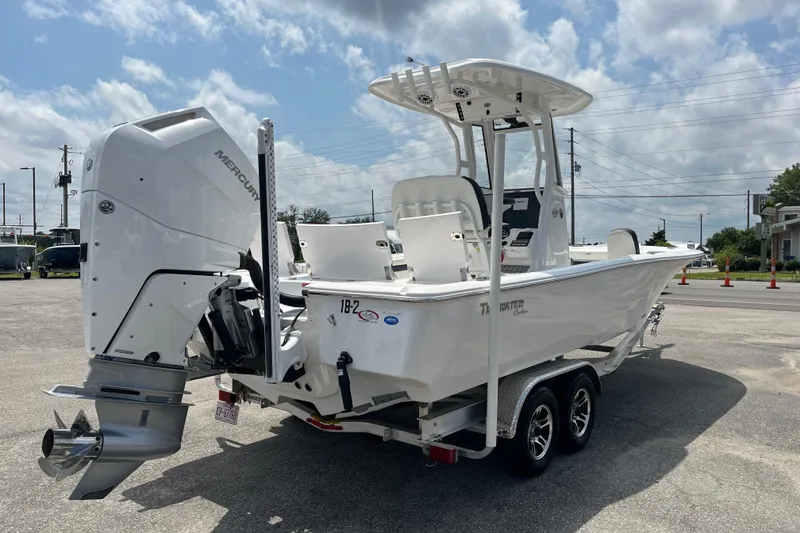 Slide: The Image of 2023 Tidewater 2500 Carolina Bay boat on trailer, featuring a powerful Mercury outboard engine. - 4