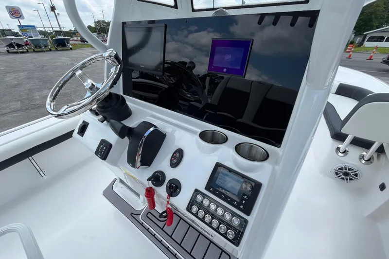 Slide: The Image of 2023 Tidewater 2500 Carolina Bay boat dashboard with steering wheel and electronic controls. - 9