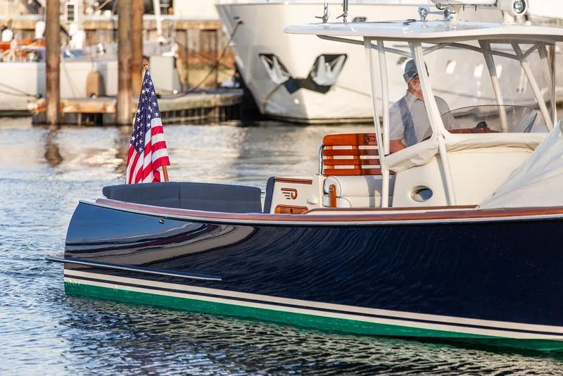 Slide: The Image of 2002 Hinckley Talaria 29C boat with American flag, docked in marina. - 10