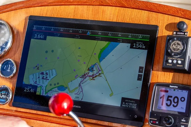 Slide: The Image of 2002 Hinckley Talaria 29C boat interior with wooden seating and steering wheel. - 24