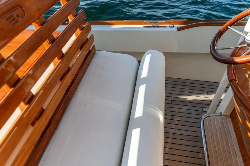Slide: The Image of Hinckley Talaria 29C 2002 boat interior with blue cushioned seating and wooden deck. - 25