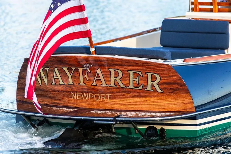 Slide: The Image of Hinckley Talaria 29C boat cruising on sunlit water, 2002 model, with American flag. - 36