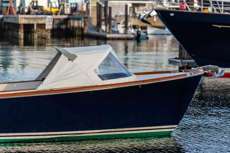 Slide: The Image of 2002 Hinckley Talaria 29C boat docked in a marina, featuring a sleek design. - 11