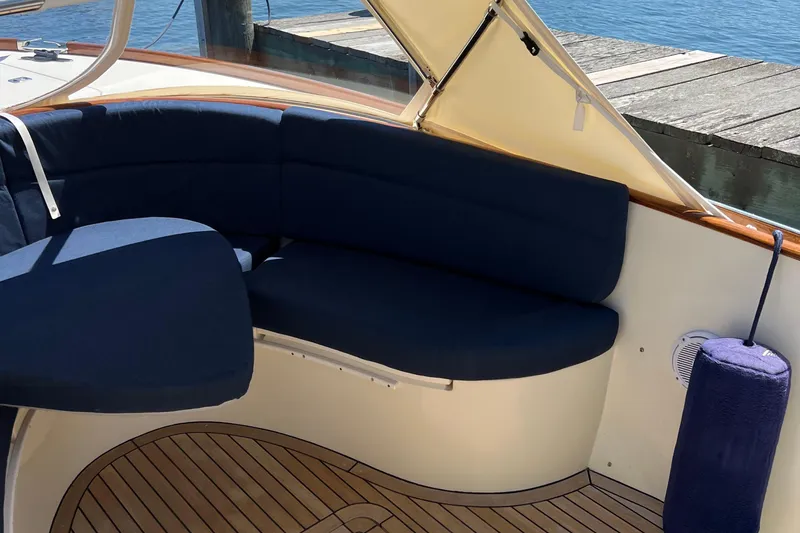 Slide: The Image of 2002 Hinckley Talaria 29C boat with wooden accents and blue seating. - 26