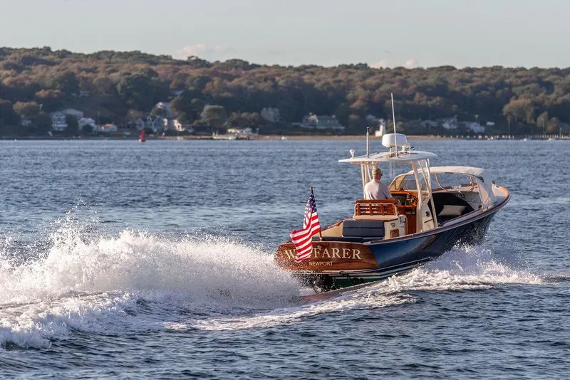 Slide: The Image of 2002 Hinckley Talaria 29C cruising on a scenic lake with American flag. - 7