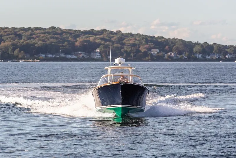 Slide: The Image of 2002 Hinckley Talaria 29C cruising on a scenic lake with forested shoreline. - 9