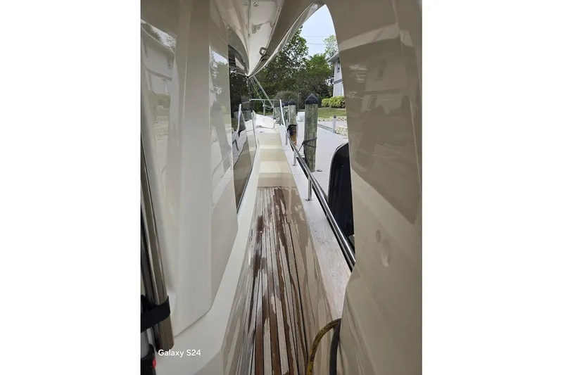 Slide: The Image of 2019 Greenline 40 yacht side deck with polished wood finish and dock view. - 18