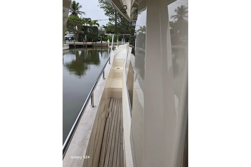 Slide: The Image of Side view of 2019 Greenline 40 yacht docked by a calm waterfront. - 19