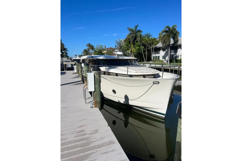 Slide: The Image of 2019 Greenline 40 yacht docked at a marina under clear blue skies. - 26