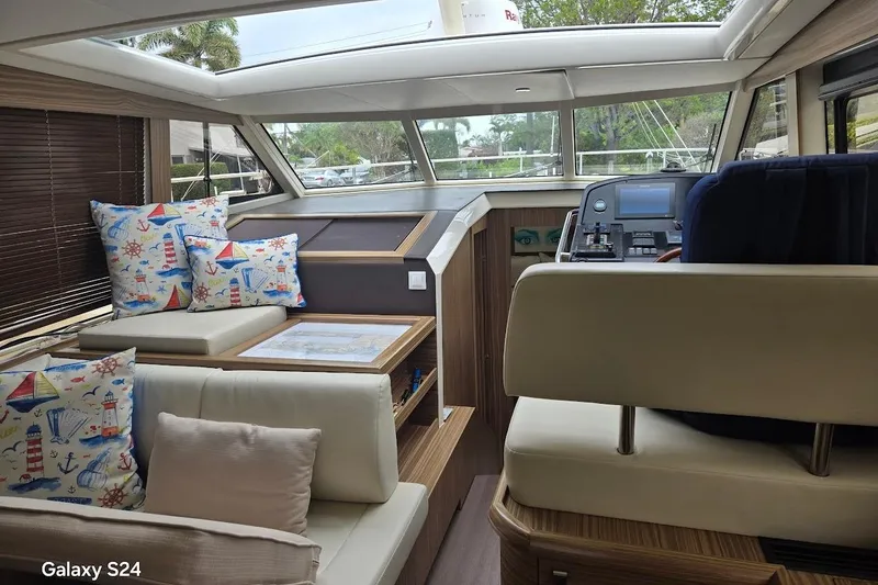 Slide: The Image of Interior of 2019 Greenline 40 yacht with nautical-themed cushions and modern helm. - 7