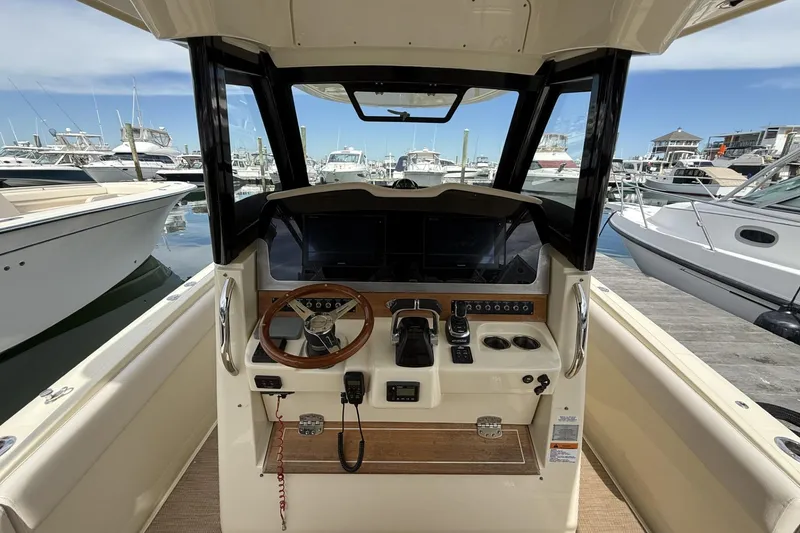 Slide: The Image of 2019 Chris-Craft Catalina 30 helm with steering wheel and controls, docked at marina. - 10