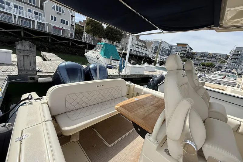 Slide: The Image of 2019 Chris-Craft Catalina 30 interior with seating and table, docked at a marina. - 13