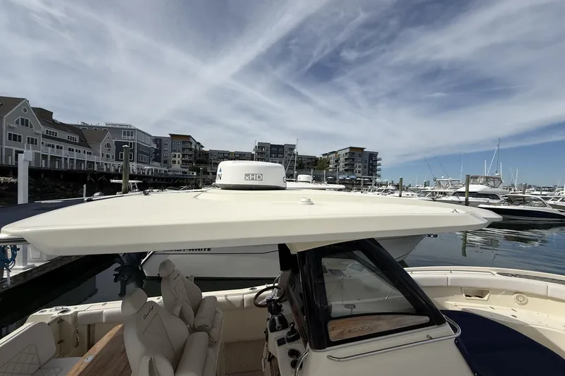 Slide: The Image of 2019 Chris-Craft Catalina 30 docked at a marina with modern buildings in the background. - 17
