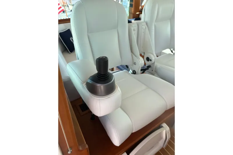 Slide: The Image of Interior of 2023 Sabre 45 Salon Express with white captain's chairs and wooden flooring. - 17