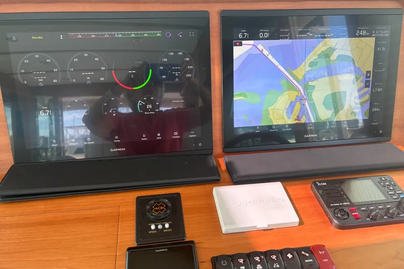 Slide: The Image of Helm of 2023 Sabre 45 Salon Express with dual Garmin displays and wooden steering wheel. - 20