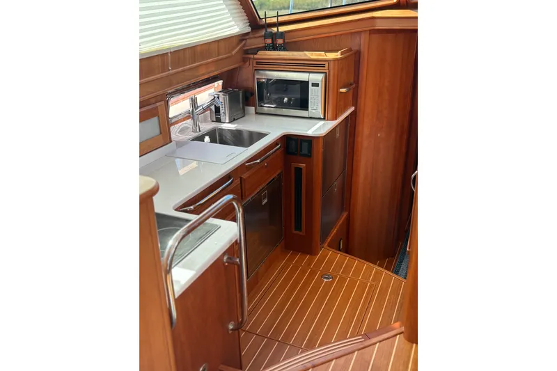 Slide: The Image of 2023 Sabre 45 Salon Express interior with hidden laundry area and wooden flooring. - 27