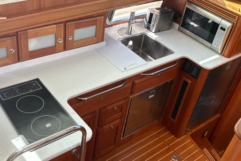 Slide: The Image of Luxurious 2023 Sabre 45 Salon Express yacht kitchen with modern appliances and wood finish. - 28