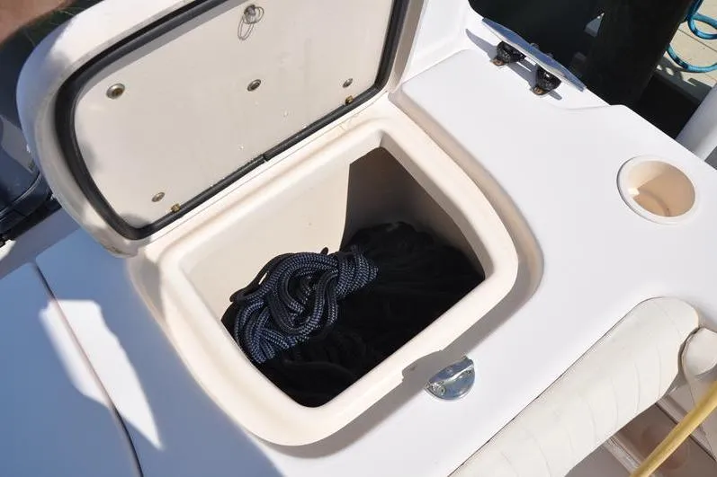 Slide: The Image of Open storage compartment on 2010 Grady-White Chesapeake 290 boat with coiled rope inside. - 11