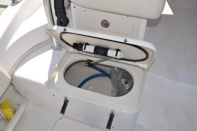 Slide: The Image of Open storage compartment on 2010 Grady-White Chesapeake 290 boat, featuring hose and equipment. - 19