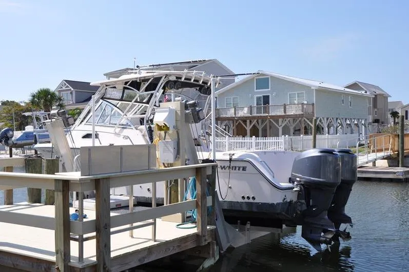 Slide: The Image of 2010 Grady-White Chesapeake 290 boat docked near waterfront homes. - 2