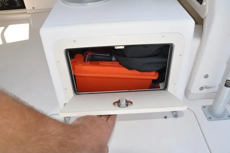 Slide: The Image of Storage compartment on a 2010 Grady-White Chesapeake 290 boat with orange toolbox inside. - 21