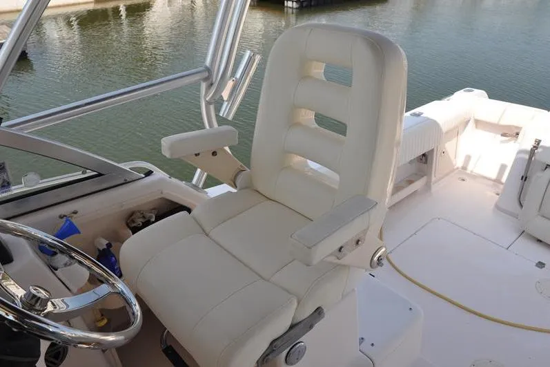 Slide: The Image of Captain's chair on 2010 Grady-White Chesapeake 290 boat, overlooking calm waters. - 23