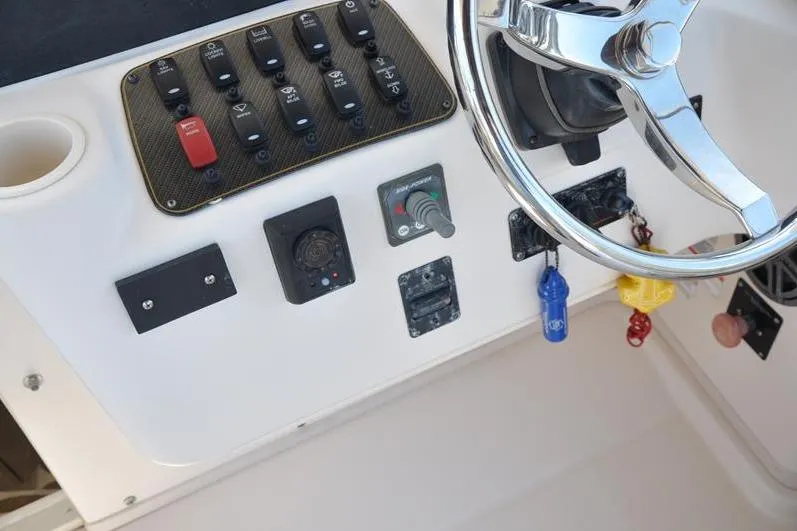 Slide: The Image of Control panel of 2010 Grady-White Chesapeake 290 boat with steering wheel and switches. - 28
