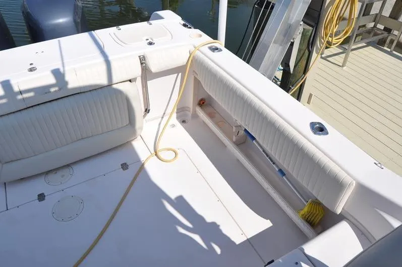Slide: The Image of 2010 Grady-White Chesapeake 290 boat deck with cushioned seating and docked at marina. - 8