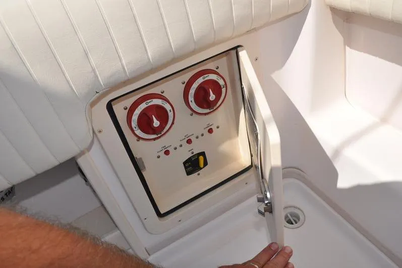 Slide: The Image of Control panel on a 2010 Grady-White Chesapeake 290 boat, featuring red dials and switches. - 9