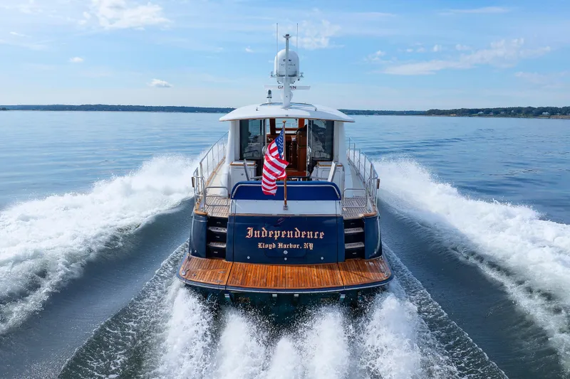 Slide: The Image of 2009 Hunt Yachts 52 Express cruising on calm waters with American flag. - 10