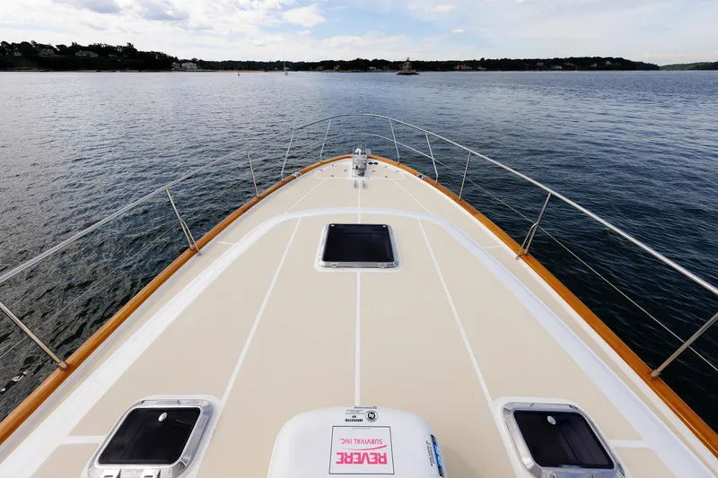 Slide: The Image of 2009 Hunt Yachts 52 Express cruising on open water, rear view with American flag. - 11