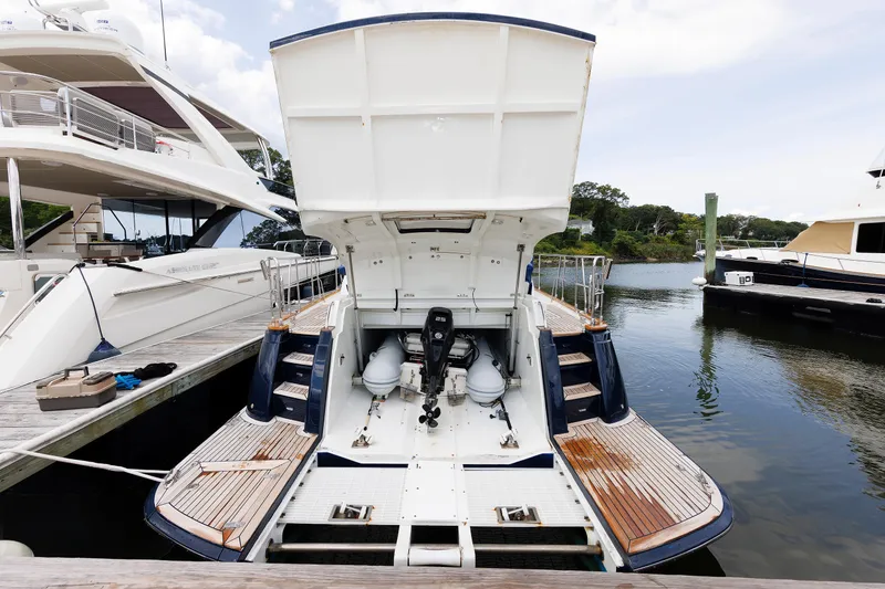 Slide: The Image of 2009 Hunt Yachts 52 Express named "Independence" on water, wooden deck, American flag. - 16