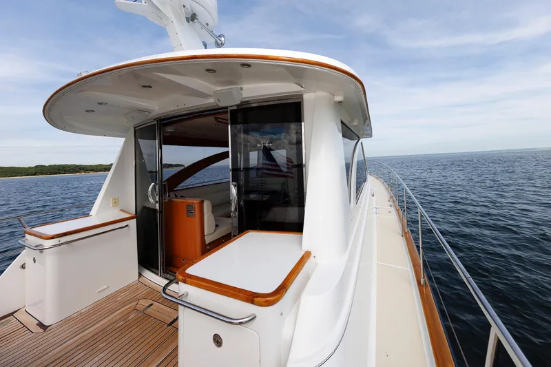 Slide: The Image of 2009 Hunt Yachts 52 Express, elegant deck view with teak flooring and ocean backdrop. - 18